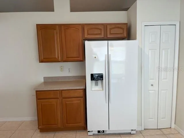 a kitchen with a refrigerator and cabinets
