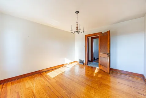 a view of a room with wooden floor ceiling fan and window