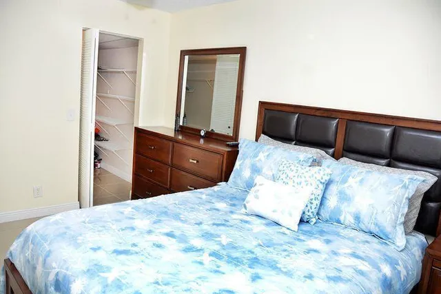 a bed sitting in a bedroom with a large mirror