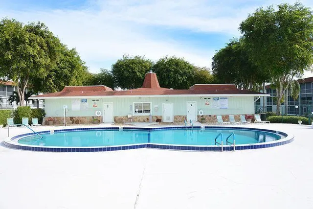 a view of backyard with swimming pool and seating space