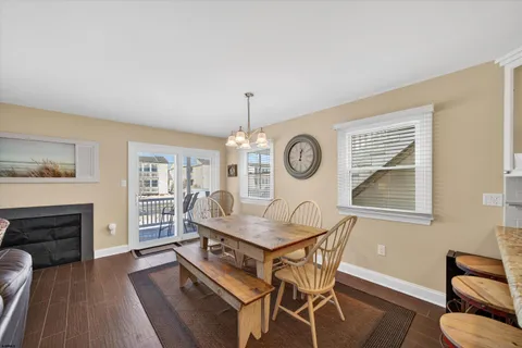 a kitchen with stainless steel appliances granite countertop a kitchen island a stove a sink a refrigerator white cabinets and wooden floor