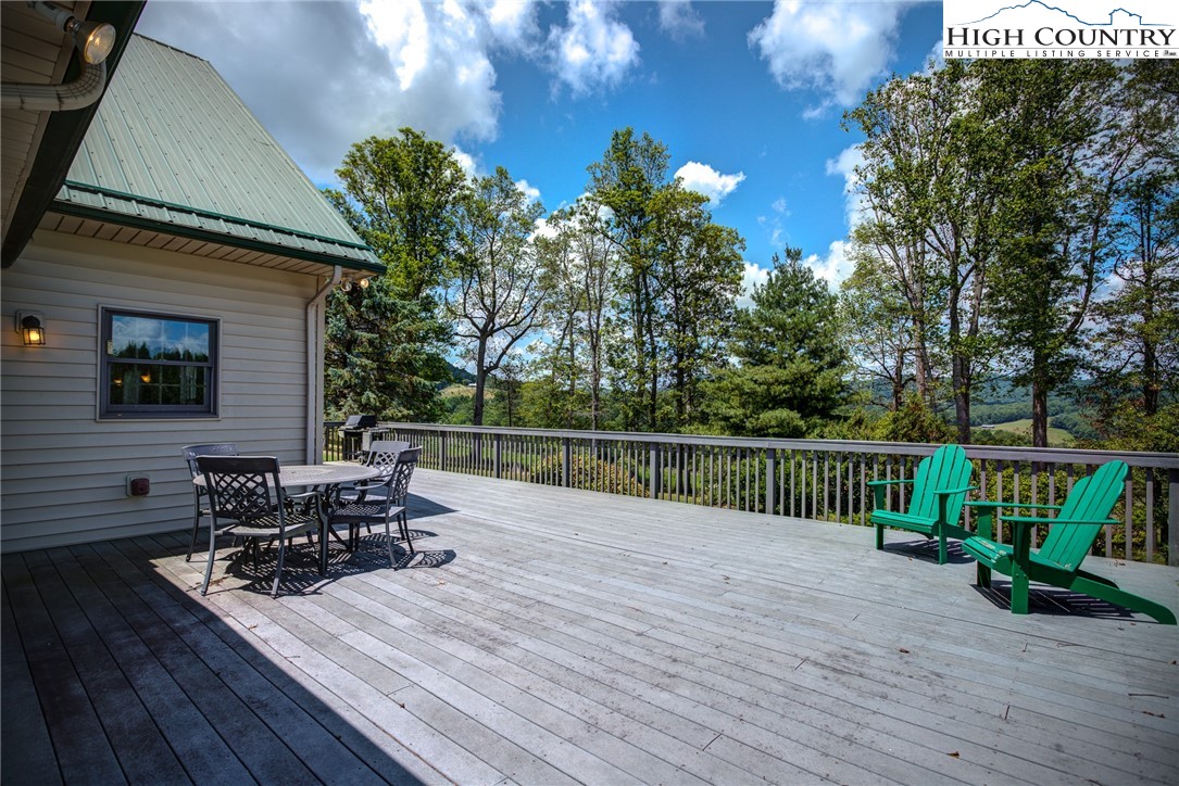 356 Irwin Farm Lane Sparta, NC 28675 - Photo 12 of 50 a view of house with deck outdoor seating and trees in the background