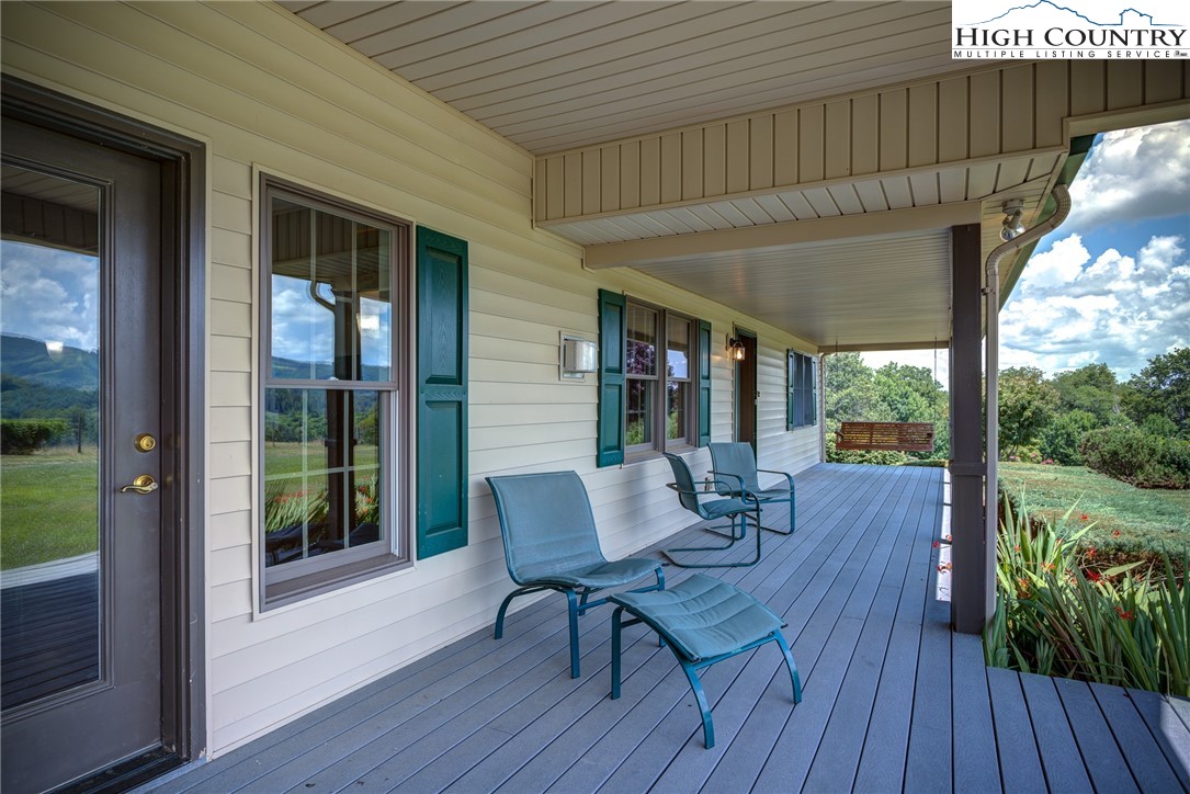 356 Irwin Farm Lane Sparta, NC 28675 - Photo 25 of 50 a view of a patio with table and chairs and wooden floor