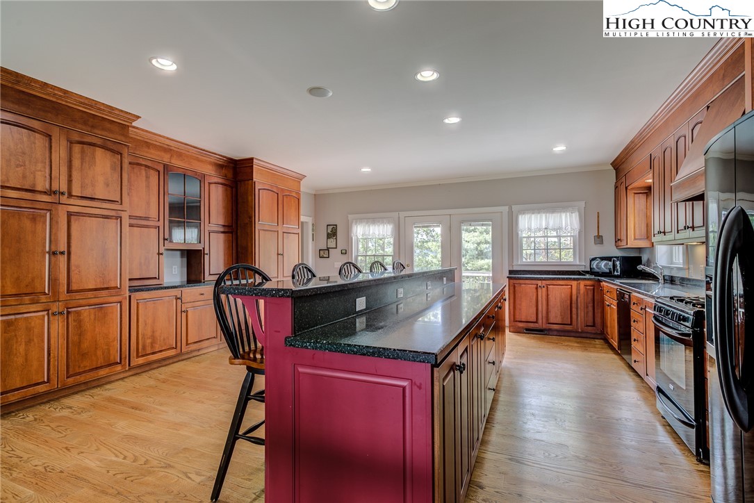 356 Irwin Farm Lane Sparta, NC 28675 - Photo 32 of 50 a kitchen with stainless steel appliances granite countertop a refrigerator a sink dishwasher a stove and a dining table with wooden floor