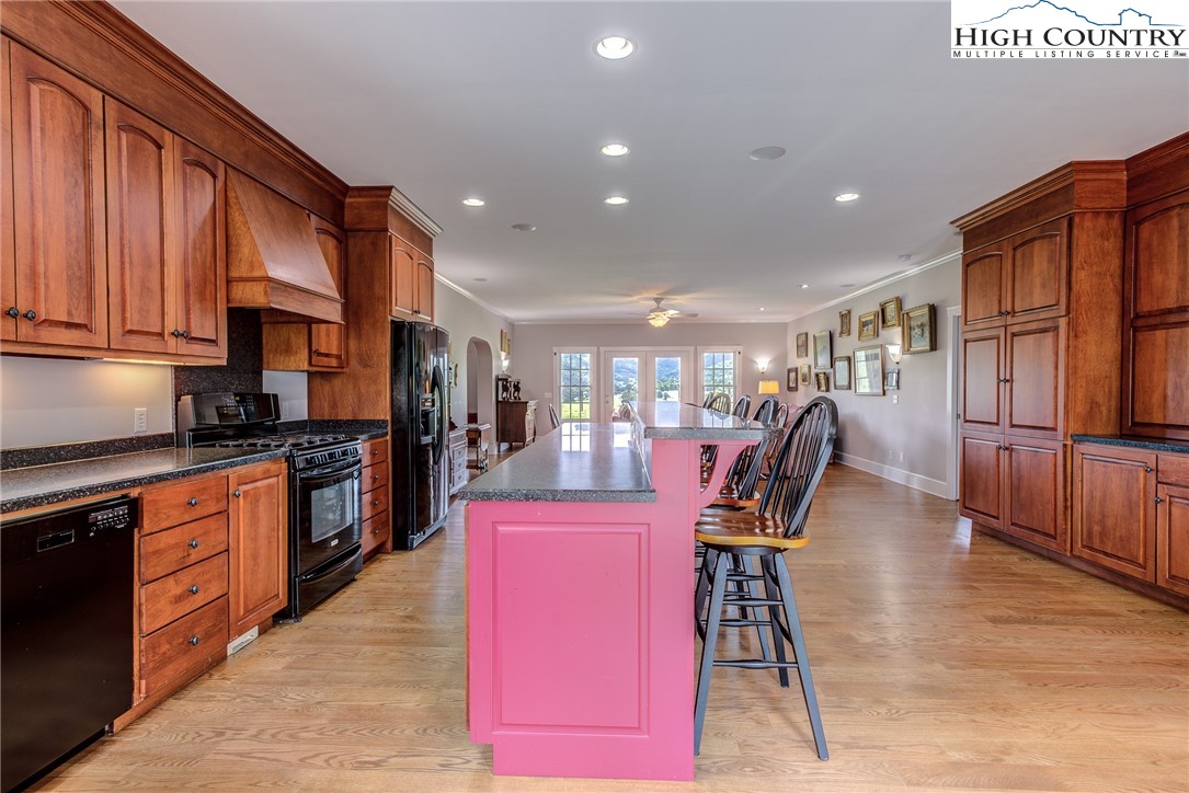 356 Irwin Farm Lane Sparta, NC 28675 - Photo 33 of 50 a kitchen with stainless steel appliances kitchen island granite countertop a table chairs in it and wooden floors