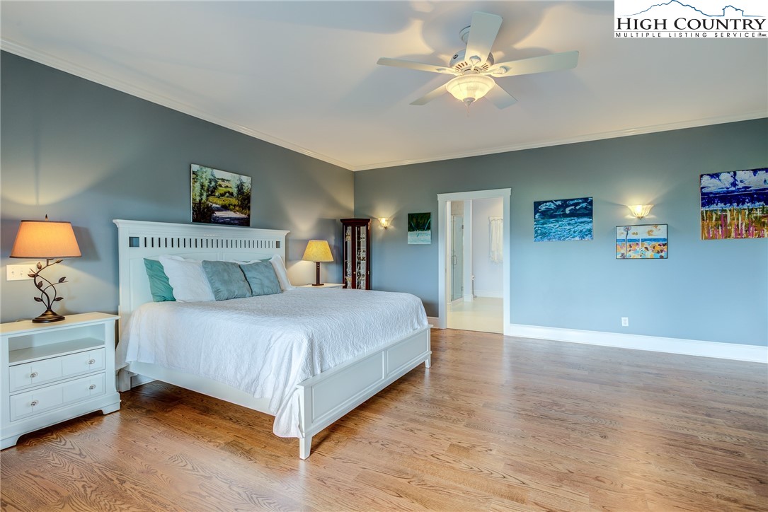 356 Irwin Farm Lane Sparta, NC 28675 - Photo 39 of 50 a spacious bedroom with a bed and a chandelier