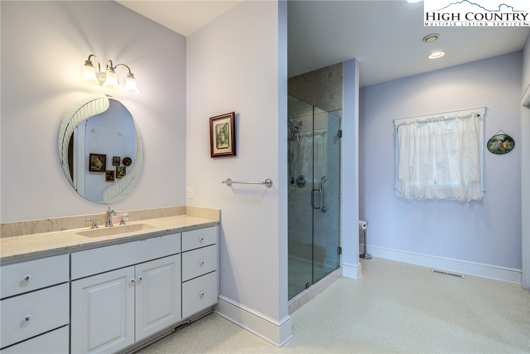 356 Irwin Farm Lane Sparta, NC 28675 - Photo 42 of 50 a spacious bathroom with a double vanity sink and a mirror
