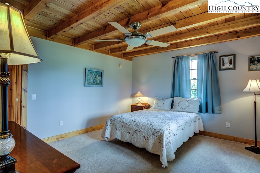 356 Irwin Farm Lane Sparta, NC 28675 - Photo 46 of 50 a bedroom with a bed a mirror and lamp