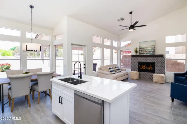 a living room with furniture a fireplace and a chandelier