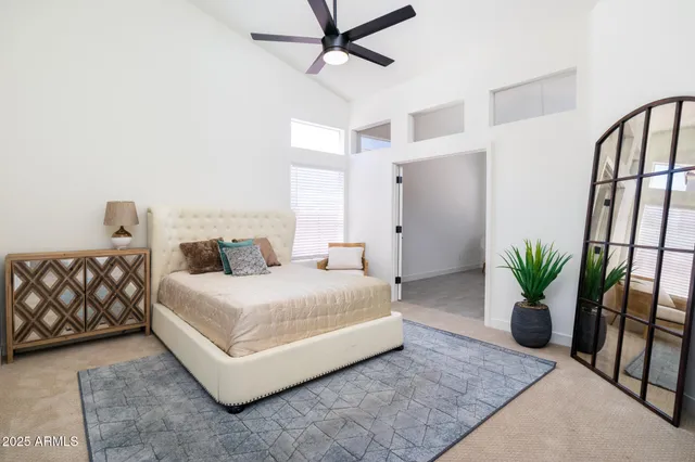 a bedroom with a large bed and a potted plant