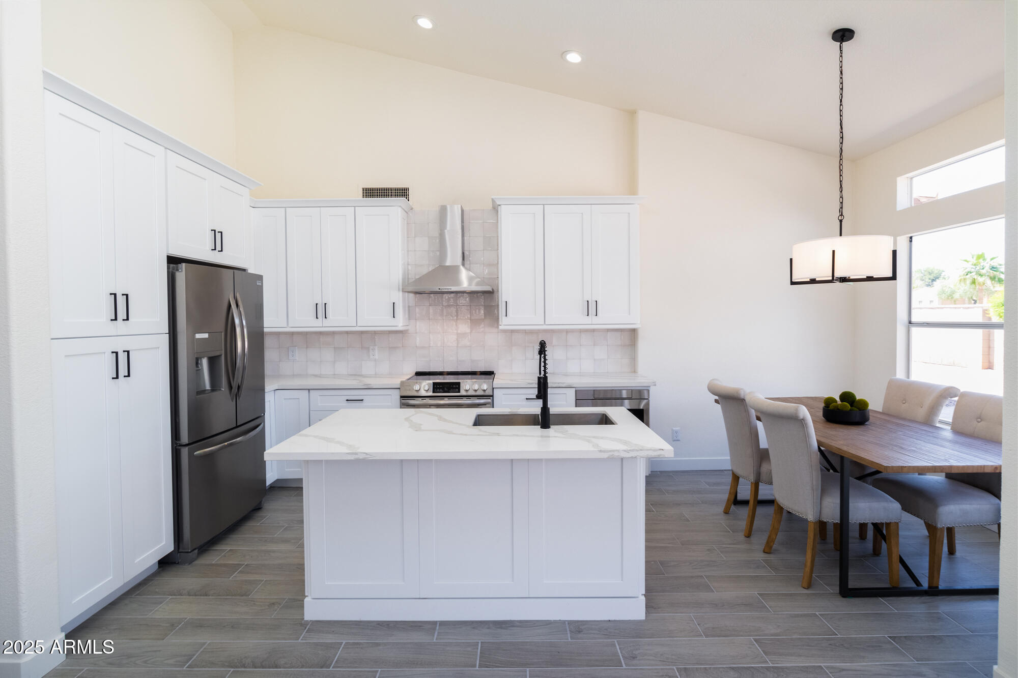 850 North Los Altos Drive Chandler, AZ 85224 - Photo 9 of 34 a kitchen with stainless steel appliances kitchen island a table chairs refrigerator and microwave