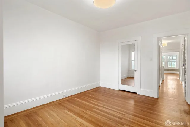 a view of empty room with wooden floor