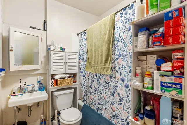 a bathroom with a toilet and a shower curtain