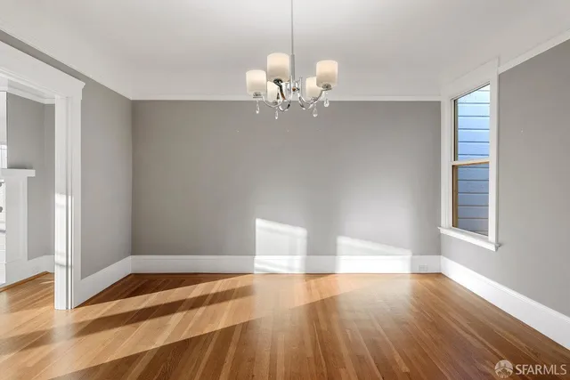 a view of a room with wooden floor and chandelier