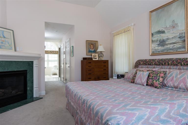 113 James Circle Mashpee, MA 02649 - Photo 16 of 21 a spacious bedroom with a bed and a fireplace