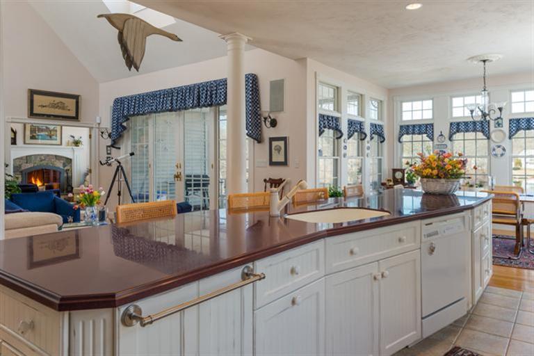 113 James Circle Mashpee, MA 02649 - Photo 9 of 21 a kitchen with white cabinets a sink and stainless steel appliances