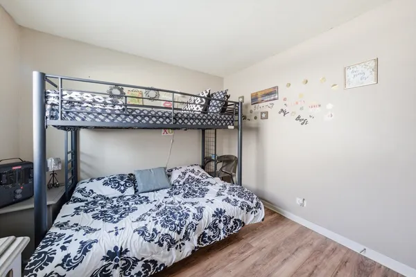 a bedroom with bed and wooden floor
