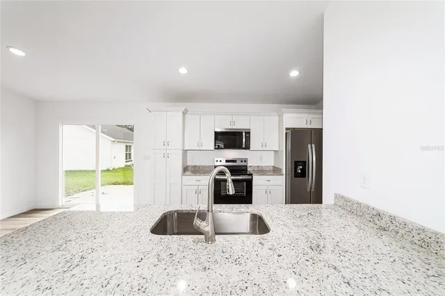 a kitchen with stainless steel appliances a sink a stove and a refrigerator