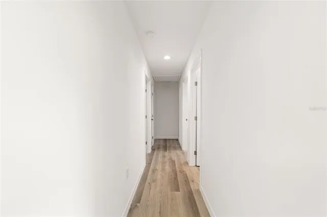 a view of a hallway with wooden floor