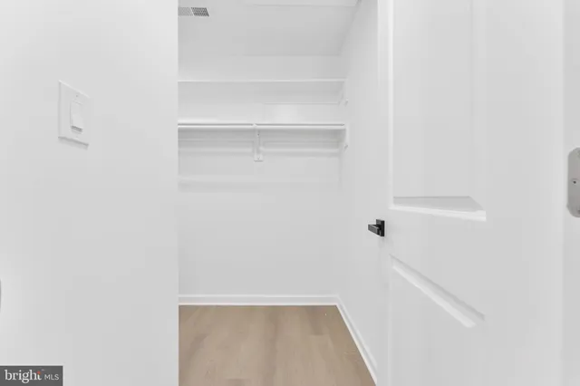 a bedroom with a large bed and a potted plant