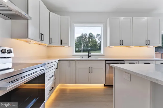 a kitchen with stainless steel appliances granite countertop a refrigerator and a stove