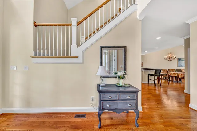 a kitchen with stainless steel appliances granite countertop a table chairs stove a sink dishwasher and cabinets with wooden floor