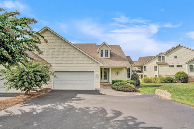an aerial view of a house with swimming pool and large trees
