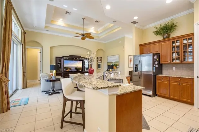a kitchen with stainless steel appliances kitchen island granite countertop a refrigerator a stove a sink dishwasher with a dining table and chairs