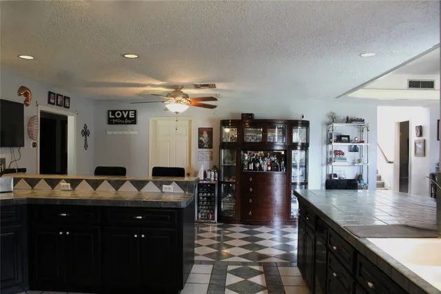 a view of kitchen with granite countertop cabinets and black appliances