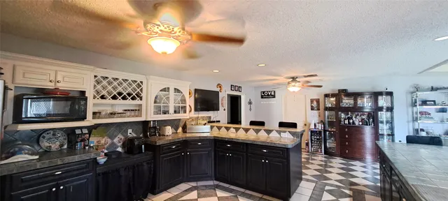 a kitchen with granite countertop a sink and cabinets