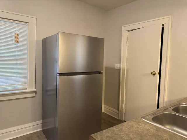 a bathroom with a refrigerator and a sink