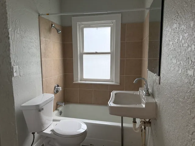 a bathroom with a sink toilet a mirror and shower