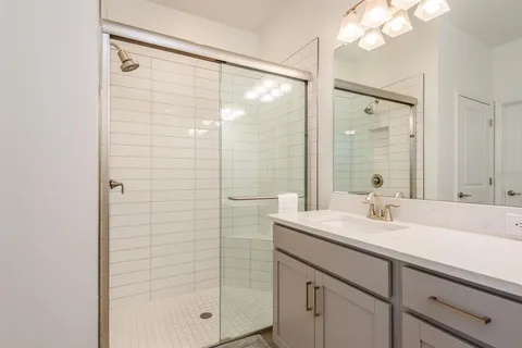 a bathroom with a sink a toilet a mirror a vanity and shower