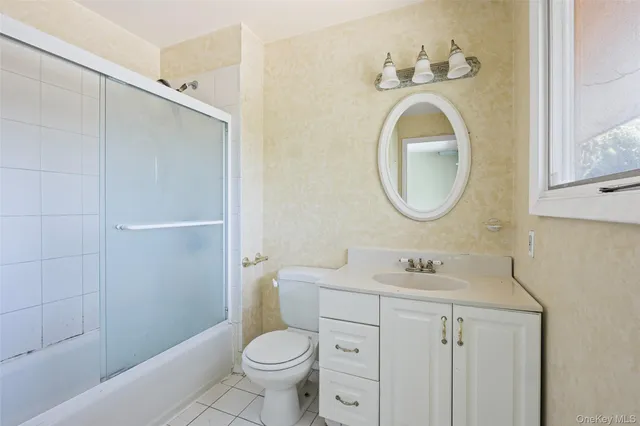 a bathroom with a granite countertop sink toilet and a mirror
