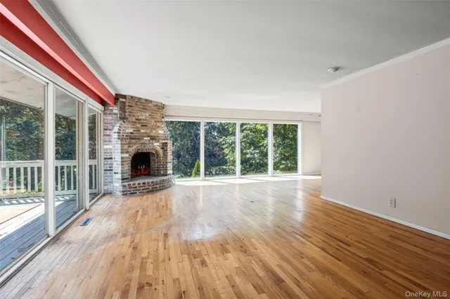 a view of empty room with wooden floor and fireplace