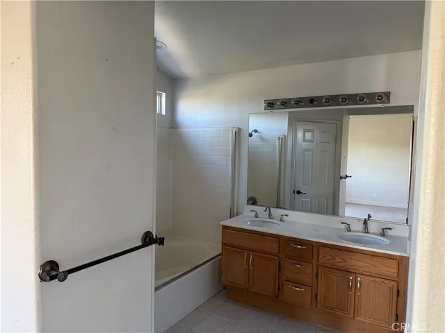 a bathroom with a double vanity sink a mirror and a bathtub