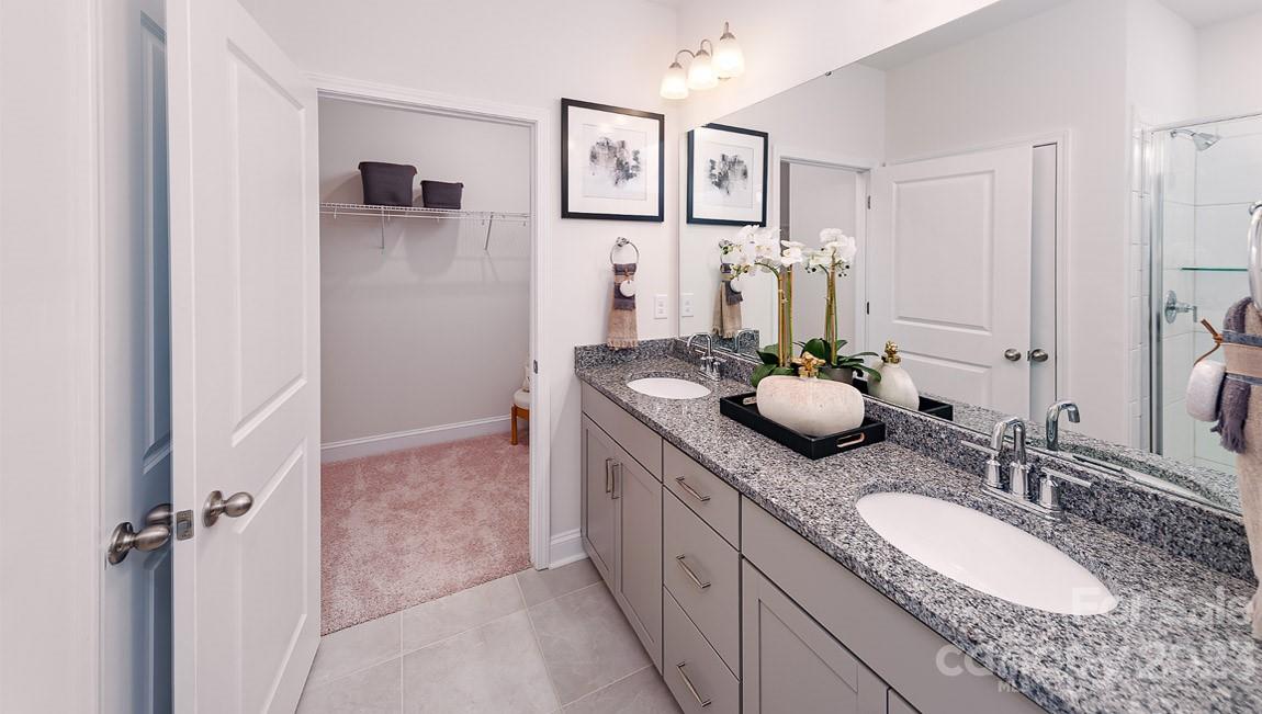 7899 Iron Road Sherrills Ford, NC 28673 - Photo 16 of 41 a bathroom with a granite countertop sink a mirror a vanity and a shower