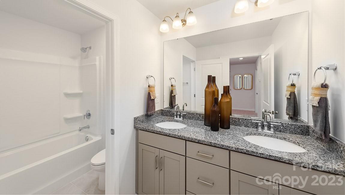 7899 Iron Road Sherrills Ford, NC 28673 - Photo 25 of 41 a bathroom with a granite countertop sink a mirror and a bathtub