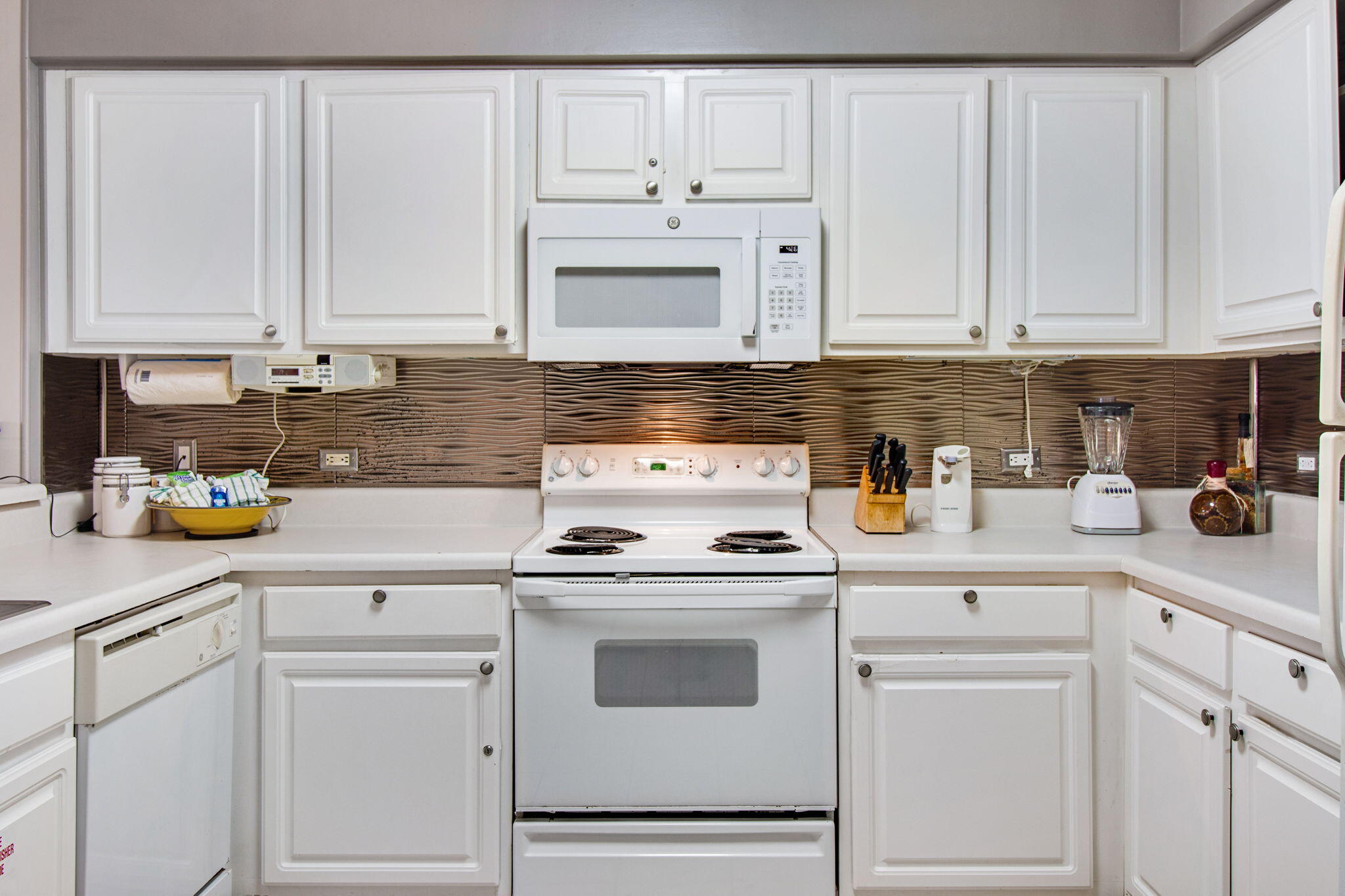 970 Highway 98, Unit 303 Destin, FL 32541 - Photo 18 of 42 a kitchen with white cabinets and white appliances