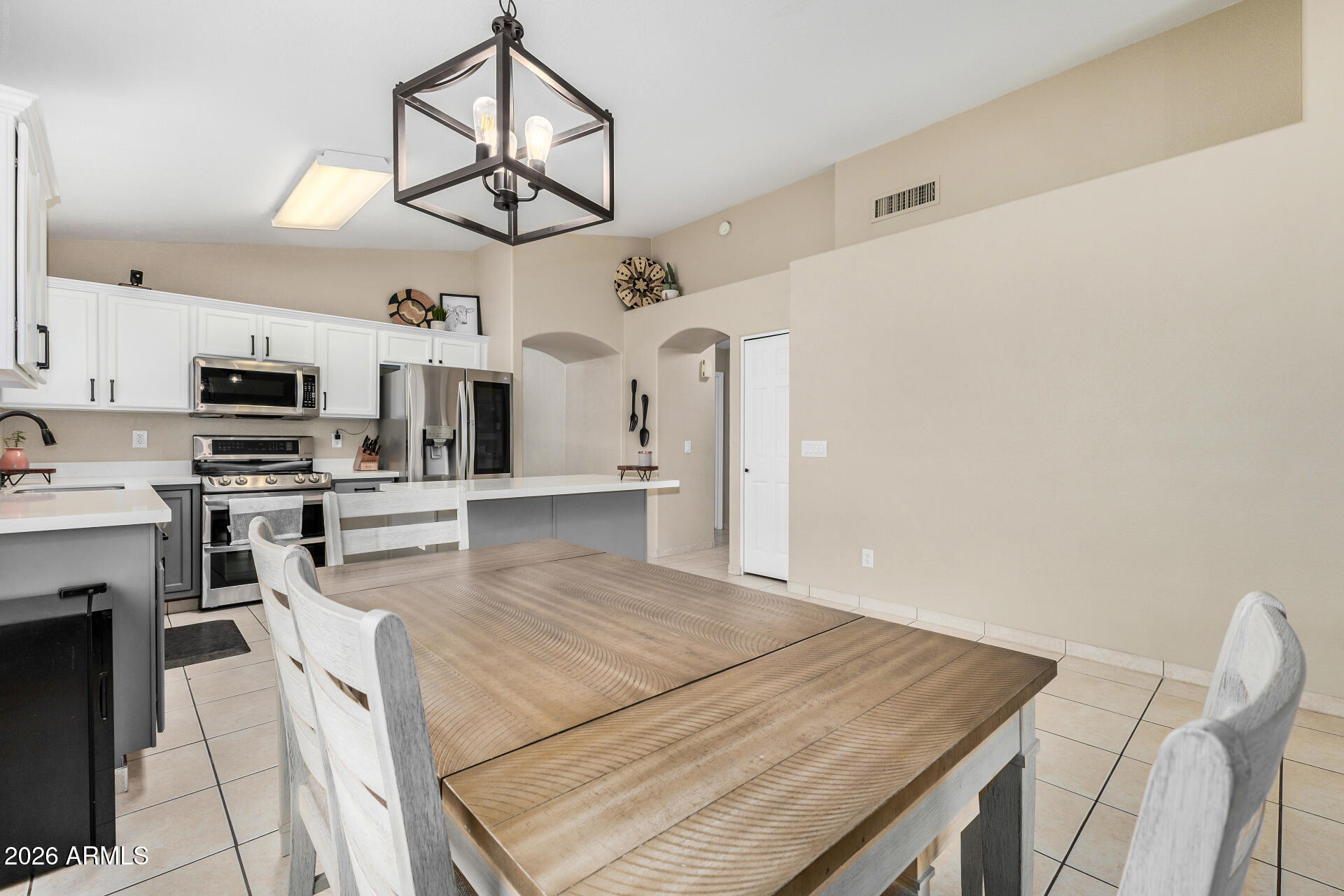 159 West Gail Drive Gilbert, AZ 85233 - Photo 21 of 46 a open kitchen with stainless steel appliances kitchen island granite countertop a stove top oven a sink dishwasher and white cabinets