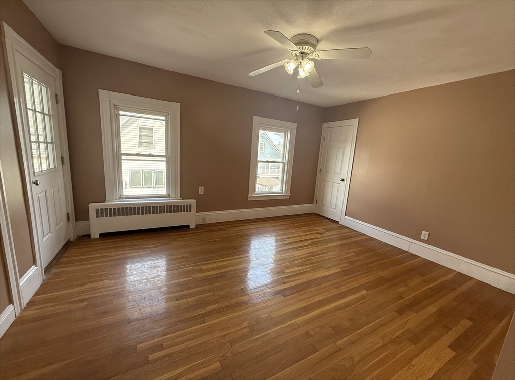 26 Lexington Street, Unit 2 Everett, MA 02149 - Photo 4 of 15 an empty room with wooden floor and windows