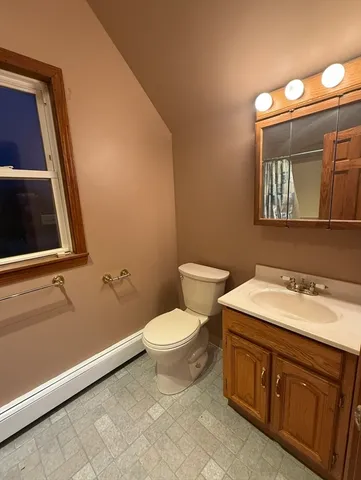 a bathroom with a toilet sink and mirror