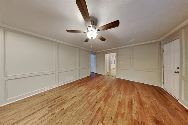 a view of an empty room and chandelier fan