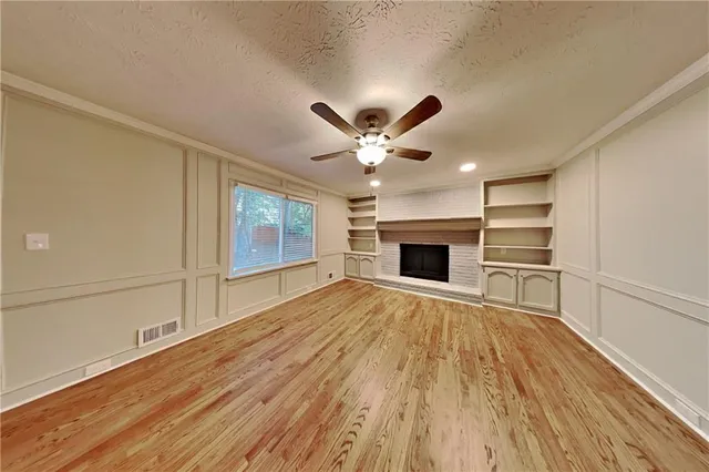 a view of an empty room with a fireplace and a window