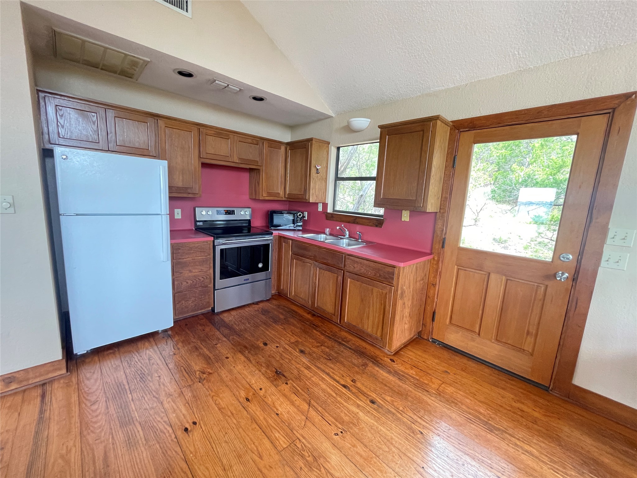 919 Little Ranches Road Wimberley, TX 78676 - Photo 6 of 13 A well-lit kitchen with natural wood flooring and cabinets awaits your culinary touch.