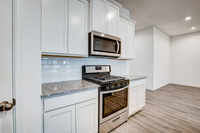 a kitchen with granite countertop a stove and a sink