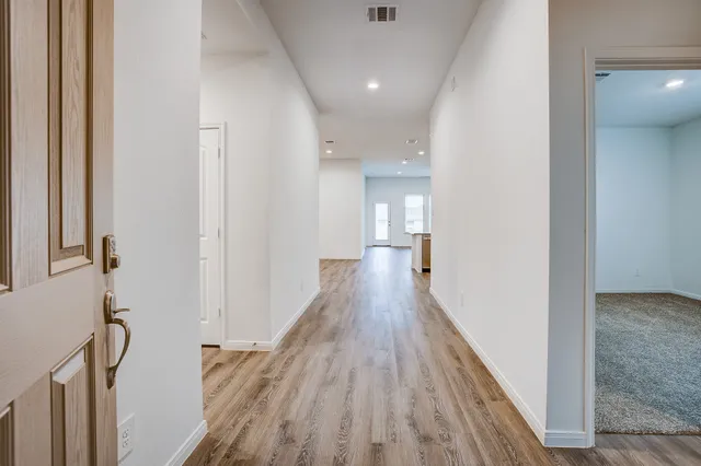 a view of a hallway with wooden floor and staircase