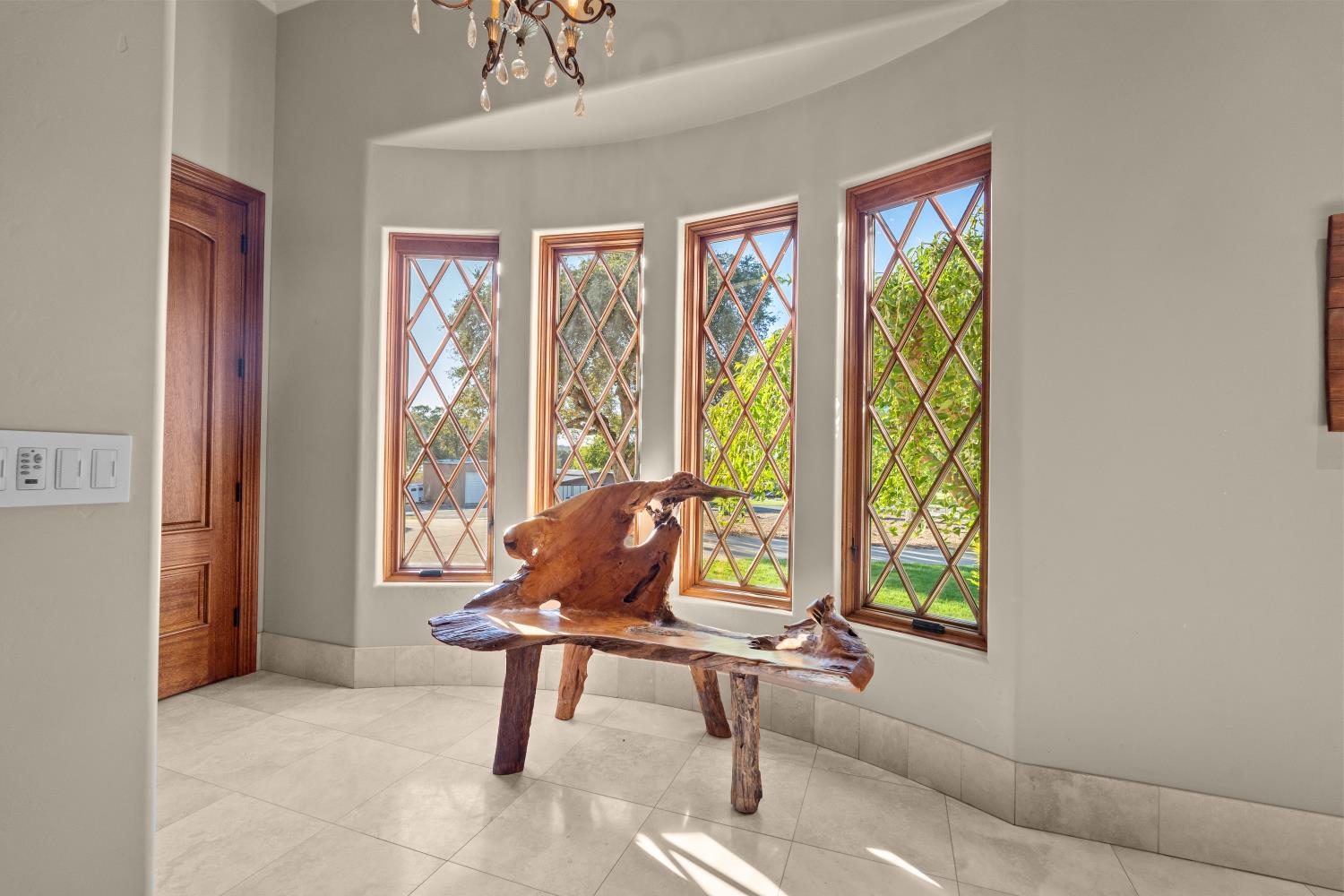 1100 Cold Springs Road Placerville, CA 95667 - Photo 27 of 97 Curved wall entryway featuring three diamond-pane windows with wood frames, light-toned tile flooring, a solid wood door, and a decorative chandelier