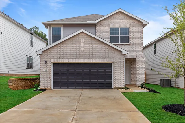 a front view of a house with a yard and garage