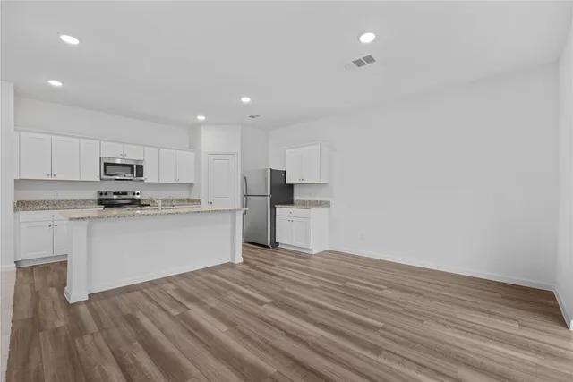 a kitchen with stainless steel appliances granite countertop a refrigerator and a stove top oven